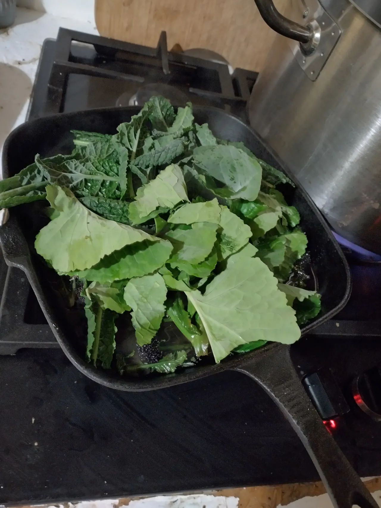 Cavolo nero and Taunton Deane kale piled on top of charred purple sprouting broccoli in the griddle pan, about to be steamed