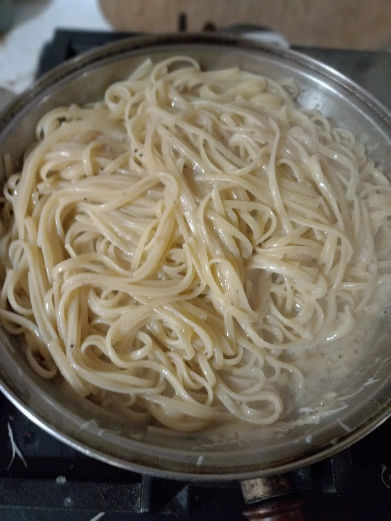 Linguine coated in silky cacio e pepe sauce, looking almost undressed but perfectly sauced