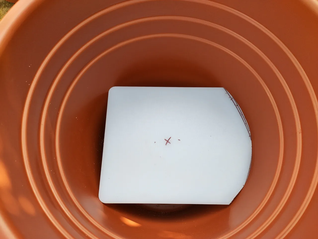 The circular chopping board platform sitting neatly inside the pot on top of the gravel layer
