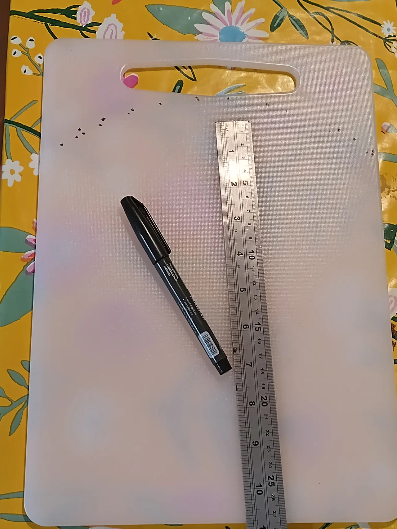 Nylon chopping board alongside the tools used to cut it: Stanley knife, metal ruler, and Sharpie marker
