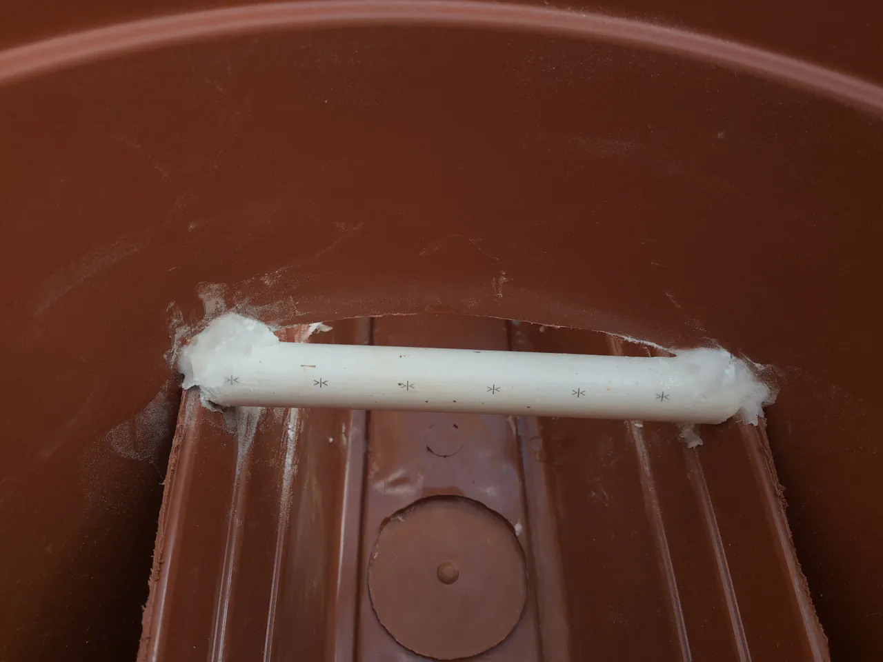 PVC pipe wedge spanning the trough gap viewed from above, glued in place to prevent the sides collapsing inward