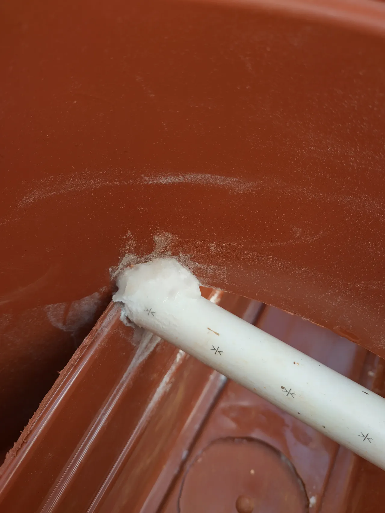 Close-up of the white superglue and bicarbonate of soda cement reinforcing the trough-to-pipe joint