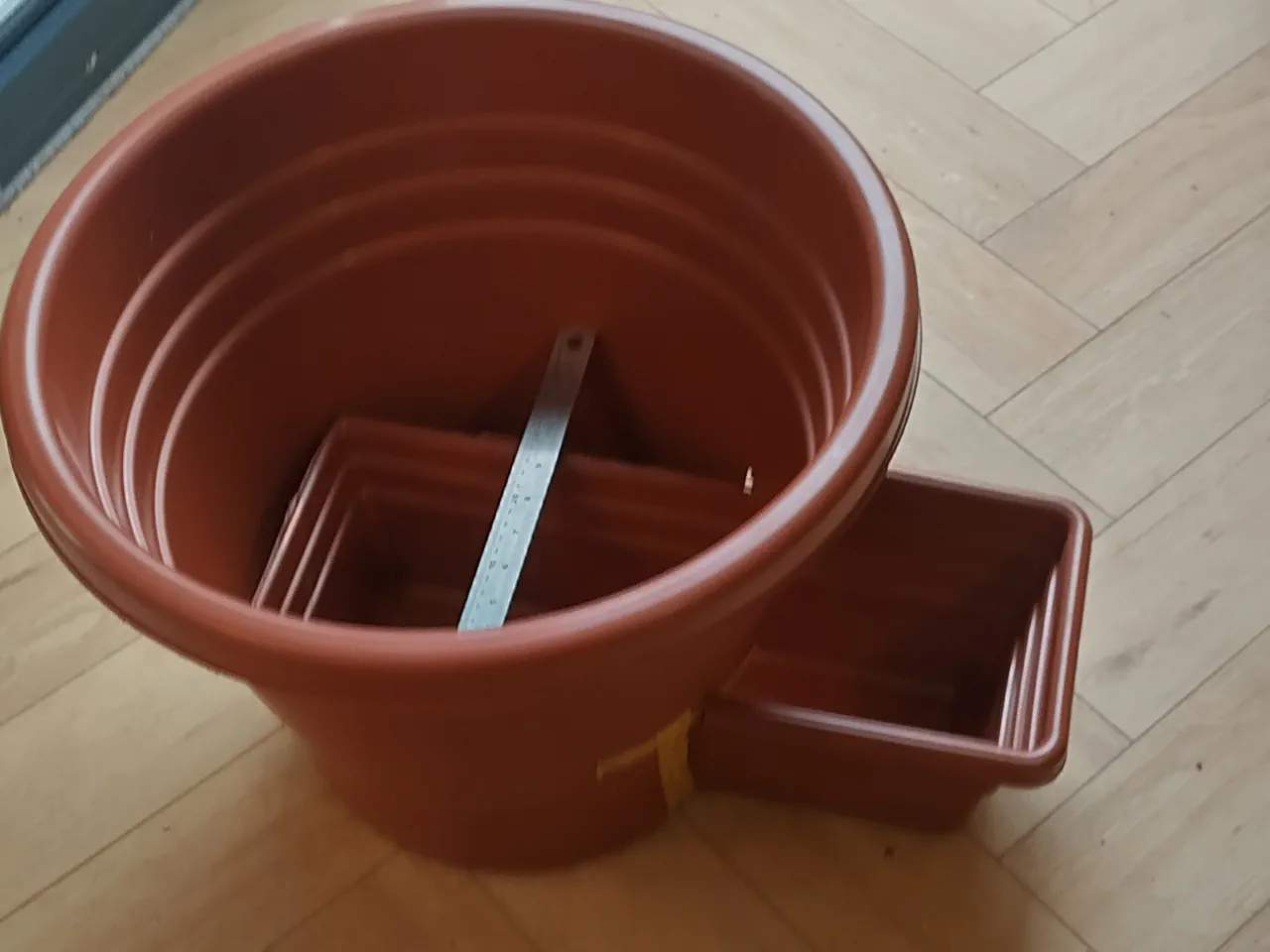 Side view showing the trimmed trough inserted through the hole in the pot wall