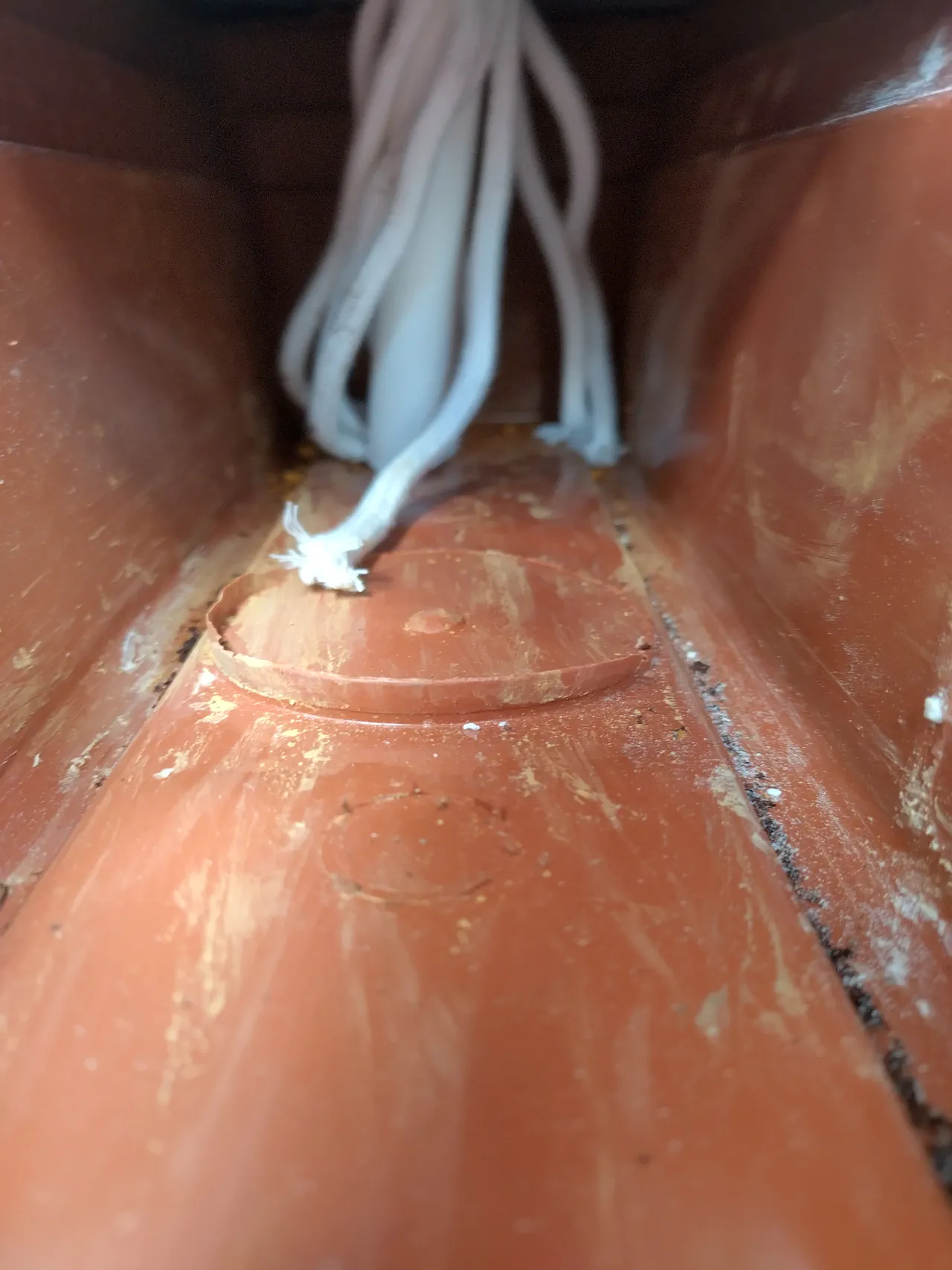 View from underneath the pot showing how the wicks enter the trough reservoir through the PVC pipe